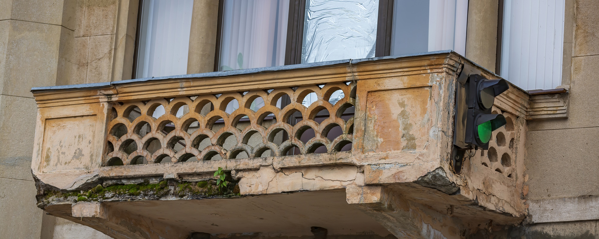 Undichter Balkon mit beschädigter Betonplatte und abplatzendem Putz an der Unterseite