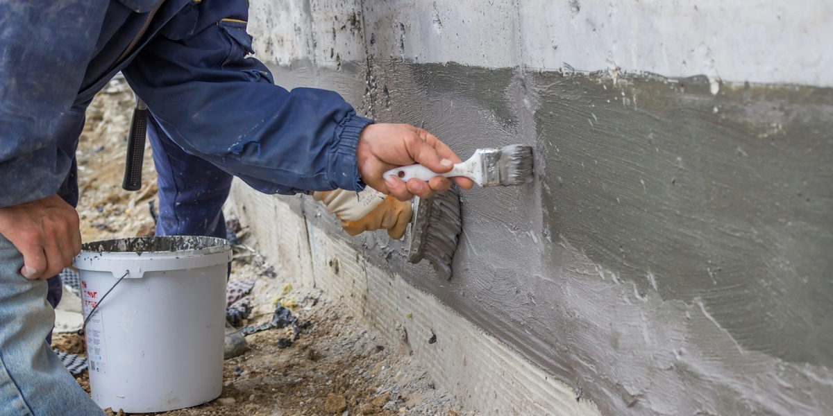 Auftrag einer mineralischen Dichtungsschlämme im Sockelbereich zur Feuchtigkeitsabdichtung