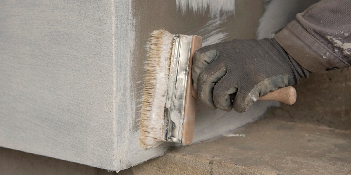 Aufbringen einer Abdichtungsschicht im Sockelbereich eines Gebäudes