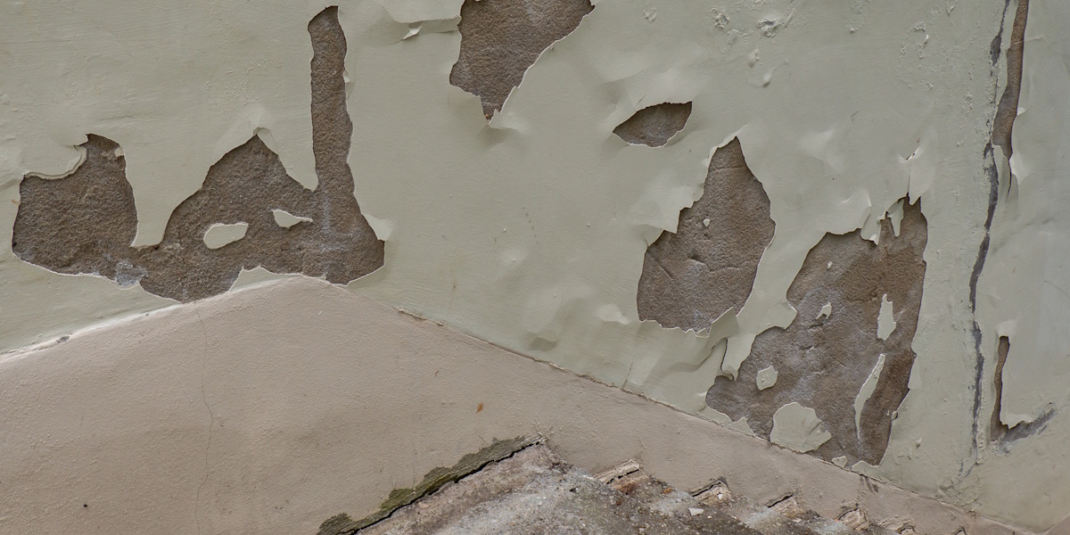 Abblätternder Putz und beschädigte Wandoberfläche durch Feuchtigkeit