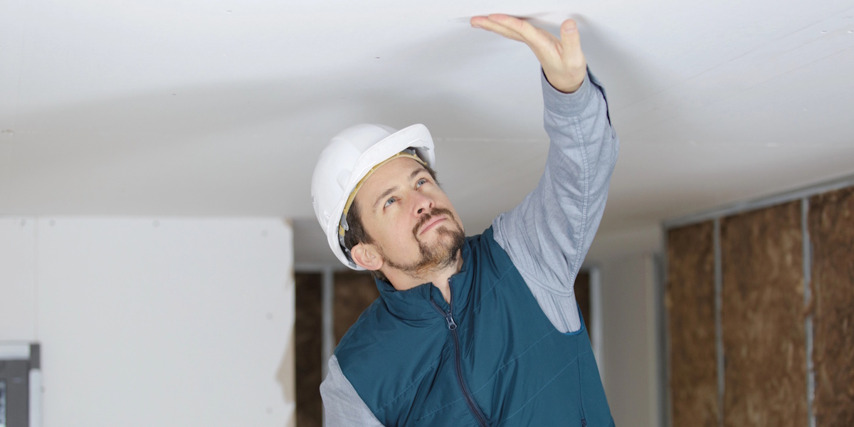 Fachmann prüft eine Decke auf Feuchtigkeit und mögliche Wasserschäden