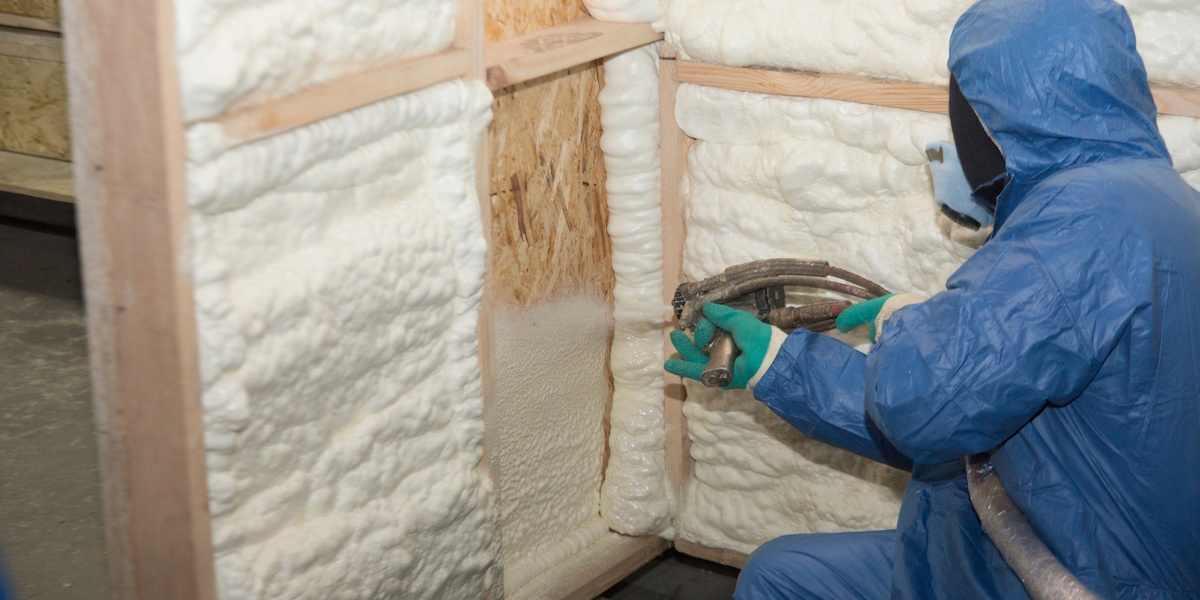 Wärmedämmung Fassade Altbau Kosten_Innendämmung Handwerker bringt Sprühdämmung in einer Wandkonstruktion auf zur Wärmedämmung im Altbau