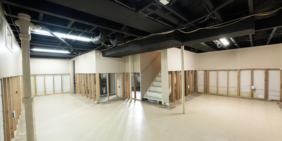 Offener Kellerraum während Sanierung mit freigelegten Wandkonstruktionen und sichtbaren Installationen