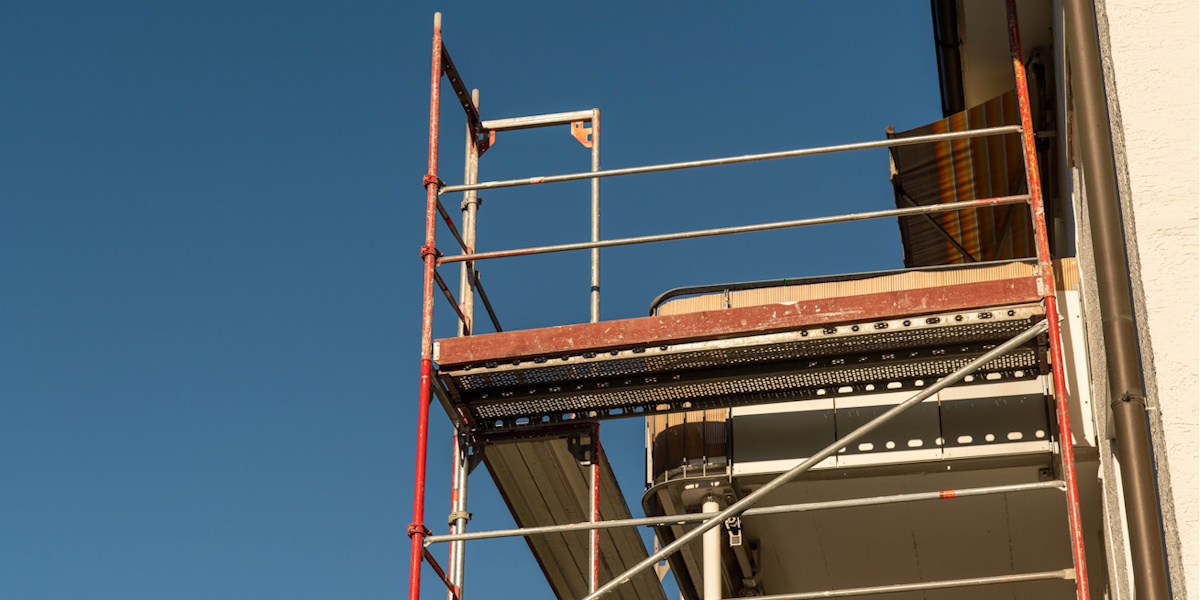 Gerüst an Hausfassade für Montage eines neuen Balkons im Obergeschoss