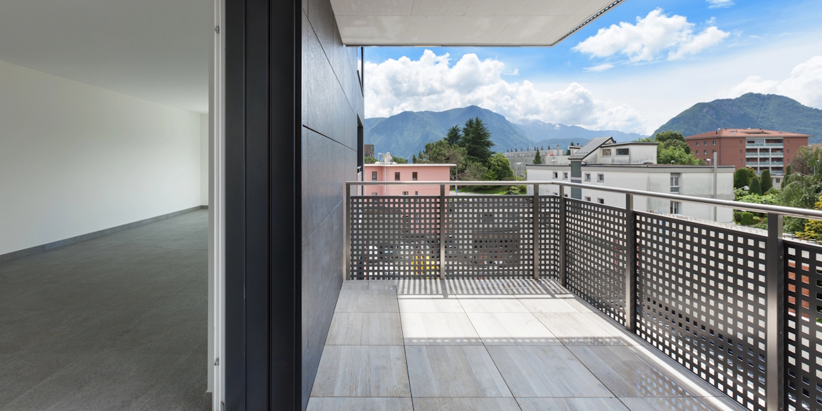 Fertig angebauter Balkon mit Geländer und Fliesenbelag an moderner Wohnanlage