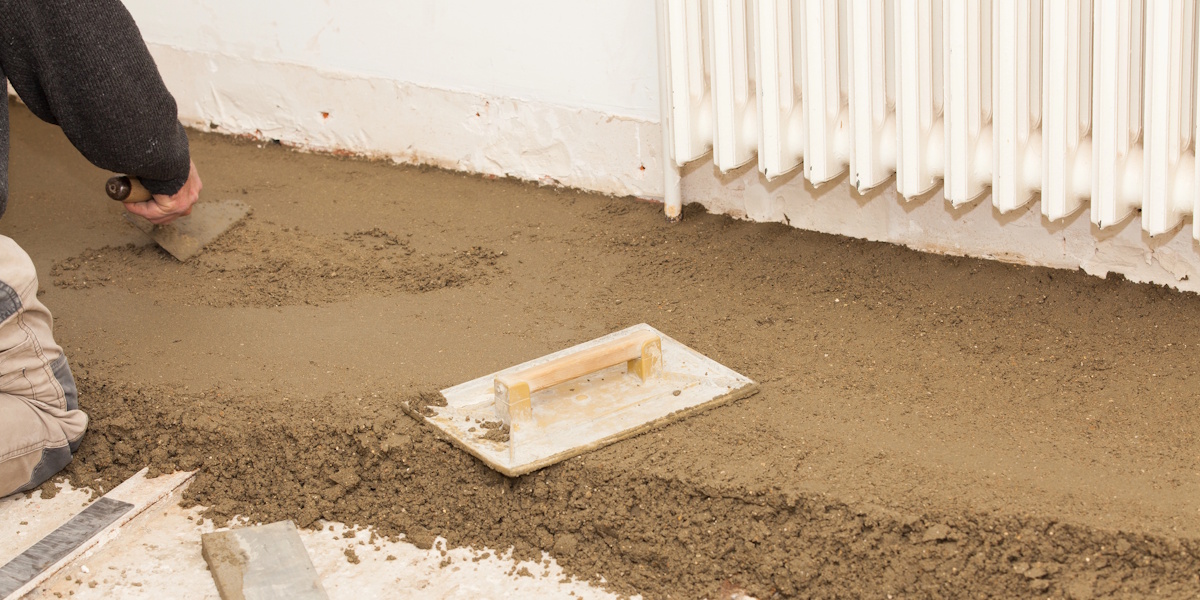 Fußbodenaufbau im Altbau_Planungsgrundlagen Frischer Bodenausgleich wird im Altbau mit einer Glättkelle eben verteilt.